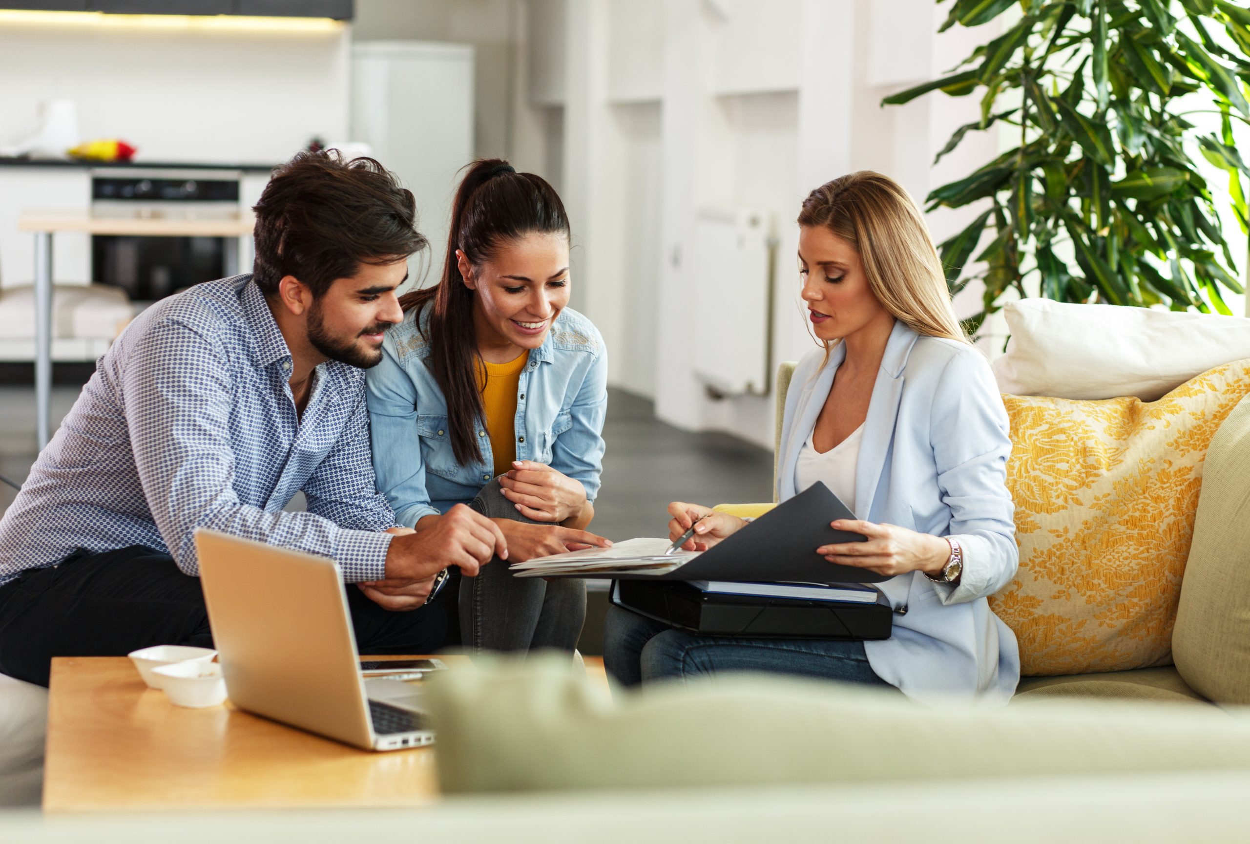 An elegant editorial image of an agent and client in a bright, refined room reviewing a small set of property materials